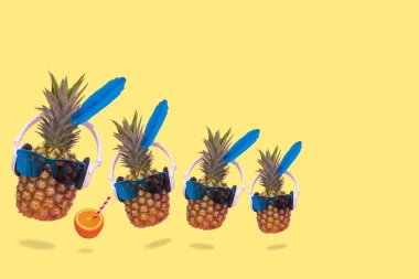 Ananas, güneş gözlüğü ve kulaklık ve taze portakal suyu takan yaratıcı bir yaz fikri. En az eğlence, parti, moda, moda ve yaz içeceği sahnesi. Kopyalama alanı için boş alan.