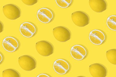 Sarı limon dilimli ve parlak sarı arka planlı bir limon deseni. Minimum yaz meyvesi konsepti. Düz besin dokusu