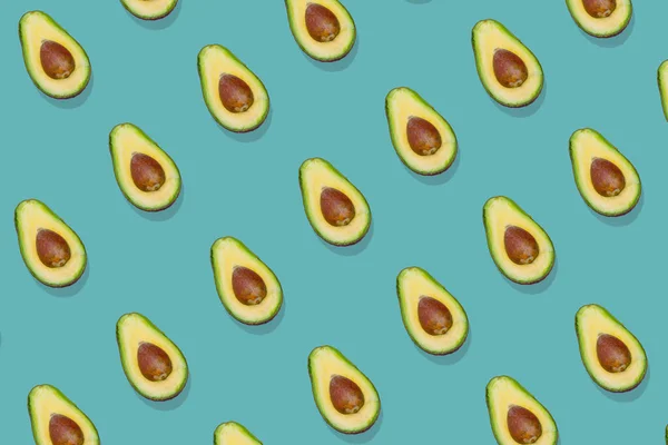 Trendy avocado  pattern on a green background. Top view. Pop art minimal design, creative summer food concept. Green avocados, minimal flat lay style.