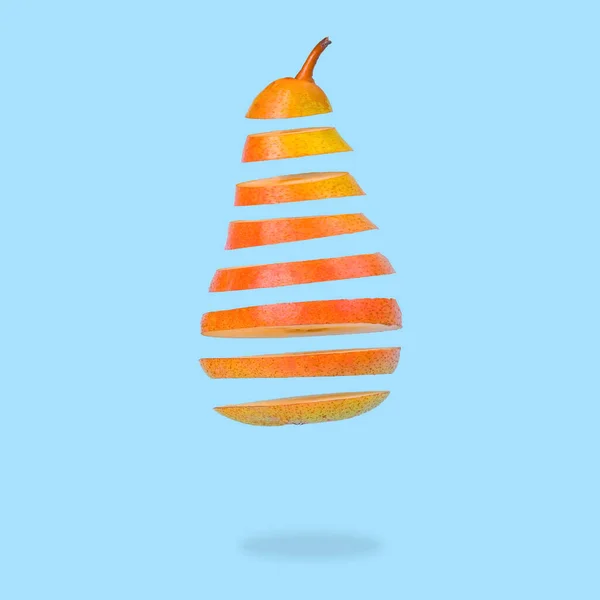 Minimal idea with Floating levitating ripe pear on pastel blue background. Vitamins, healthy food concept. Sliced pear floating in the air. Creative concept with flying fruits.