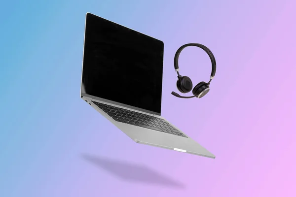 Laptop Computer Mit Leerem Bildschirm Und Der Luft Schwebendem Headset — Stockfoto