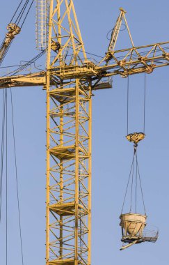 Mavi gökyüzü arka planında vinç olan bir inşaat alanı. Ağır kaldırma endüstrisi için büyük bir vinç inşaat aracı. İş mühendisliği ekipmanları modern. Endüstri kavramı
