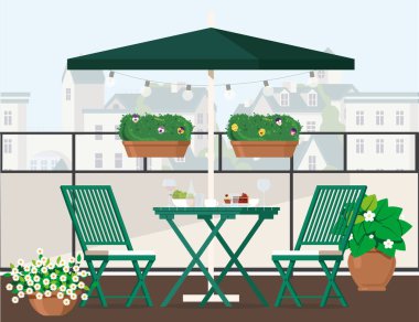 Şemsiyenin altında yeşil mobilyalar ve şehir manzaralı balkon.
