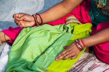 Bayan terzi el yapımı kumaş dikiyor.