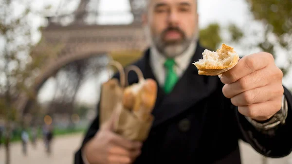 Jóképű Férfi Öltönyt Kabátot Visel Francia Gurulást Eszik Eiffel Torony — Stock Fotó