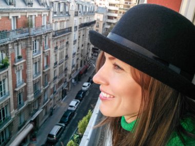 Paris 'te sonbahar güneşli gününün tadını çıkaran kadın gezgin.