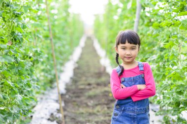 Çocuk bahçıvan portresi, tarlada gülümseyerek poz veriyor.