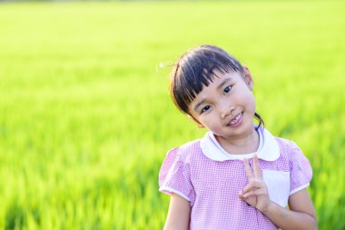 Okul üniformalı küçük kız yeşil pirinç tarlası geçmişi koydu.