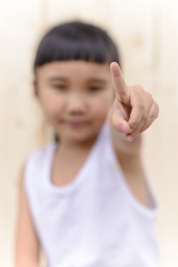 Çocuk el işareti ve tahta duvarda bulanık bir yüz.