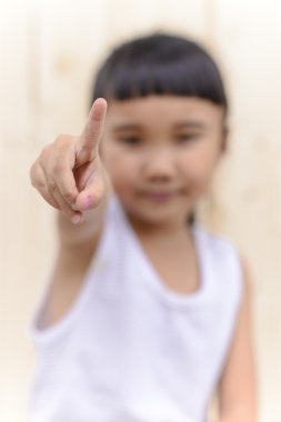 Çocuk el işareti ve tahta duvarda bulanık bir yüz.