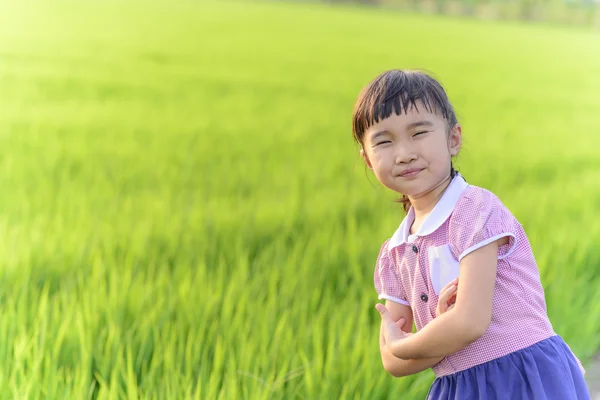 Kleines Mädchen Mit Schuluniform Lächeln Auf Grünem Reisfeld Hintergrund — Stockfoto