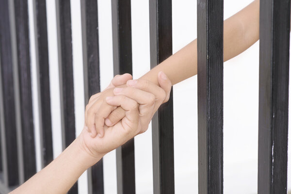 Man hand hold kid hand from the black grid