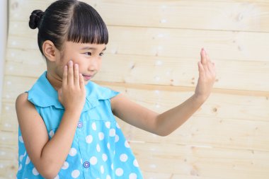 Küçük kız, bulanık ahşap arka planla kendini kontrol et.