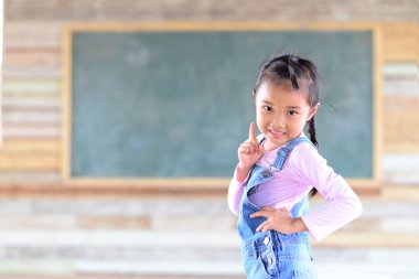 Yeşil karatahta geçmişi olan küçük bir kız portresi.