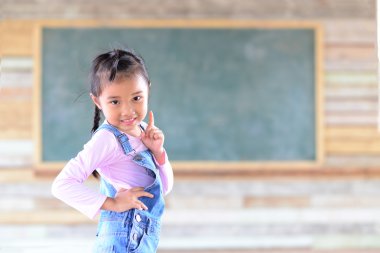 Yeşil karatahta geçmişi olan küçük bir kız portresi.