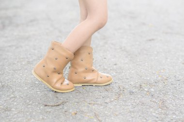 Küçük kız bacaklarını asfalt yol üstünde çizme ile