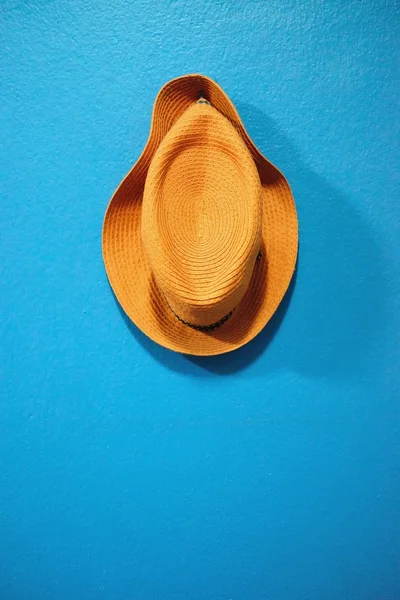 Pomarańczowy kapelusz umieścić na ścianie niebieski — Zdjęcie stockowe