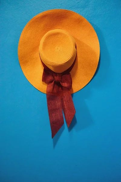 Chapéu laranja com fita na parede azul vintage — Fotografia de Stock