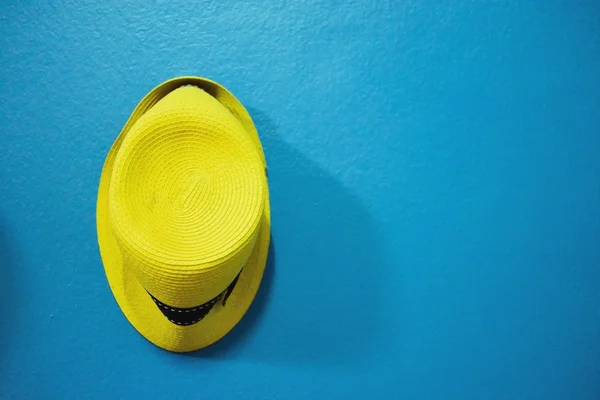 Yellow hat on blue vintage wall — Stock Photo, Image