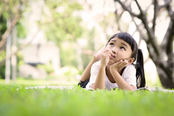 Asiático niño pensando mientras jugando en el jardín — Foto de Stock