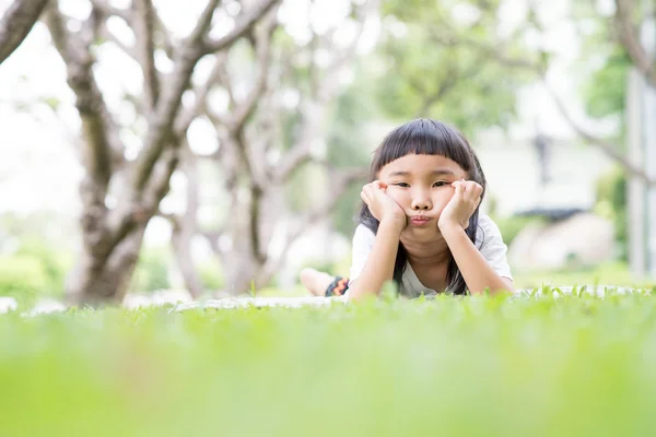 Kid tänkande i trädgården — Stockfoto