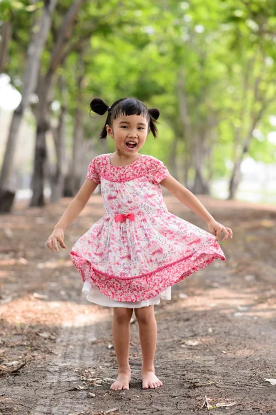 Asiatico bambino spettacolo suo rosso abito e dancing in il giardino — Foto Stock