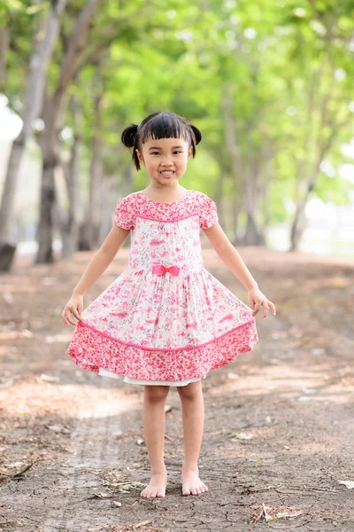 Asiatische Kind zeigen ihr rotes Kleid auf Natur Hintergrund — Stockfoto