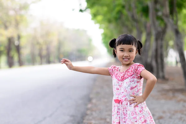 Kid doing a waving call on the roadside — Stock Photo, Image