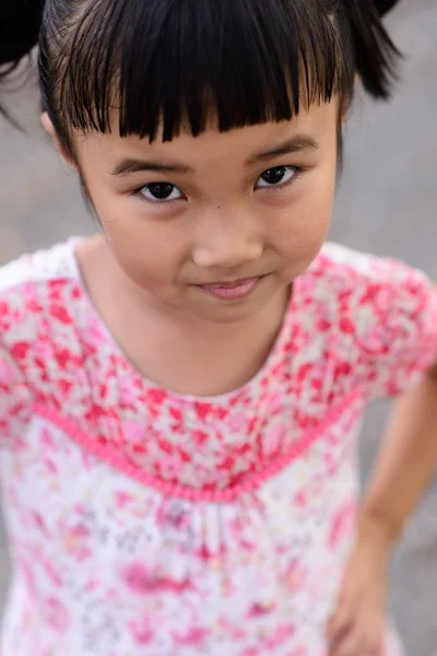 Детский портрет с красным платьем на голове — стоковое фото