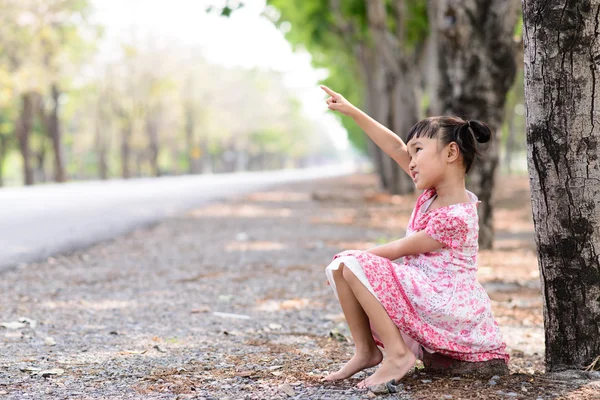 Niño con vestido rojo punto a algo — Foto de Stock