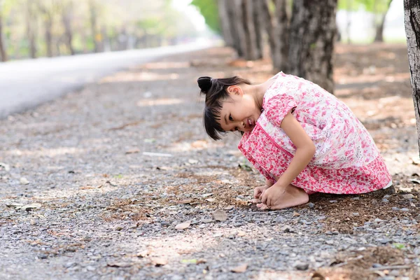 Kind mit rotem Kleid sitzt auf dem Boden — Stockfoto