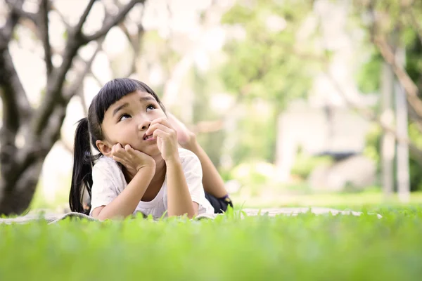 Asyalı çocuk bahçede oynarken düşünme — Stok fotoğraf