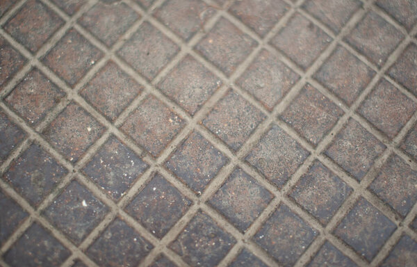 Iron manhole cover with a true symmetrical checkered pattern as a texture.
