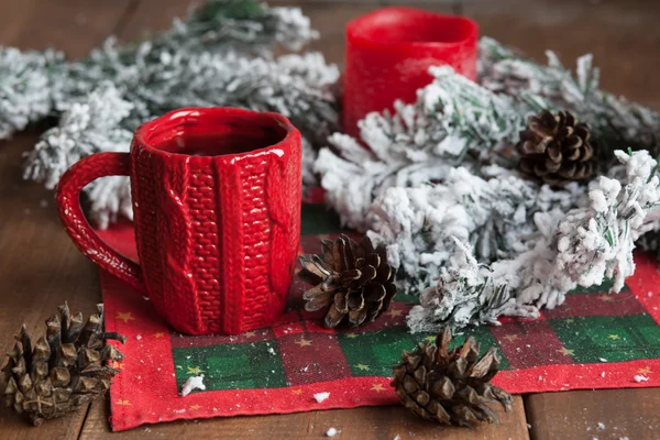 cup of tea, fir cones, fir branches in the snow, a candle