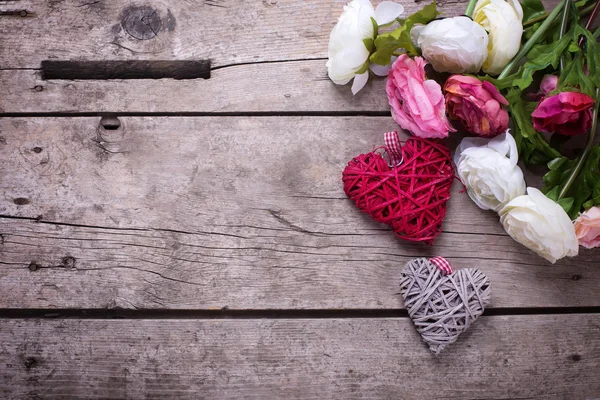 Flores cor de rosa e coração decorativo branco — Fotografia de Stock