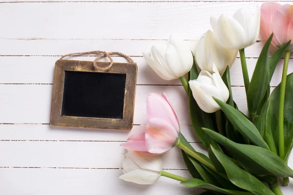 Розовые тюльпаны и пустая доска — стоковое фото