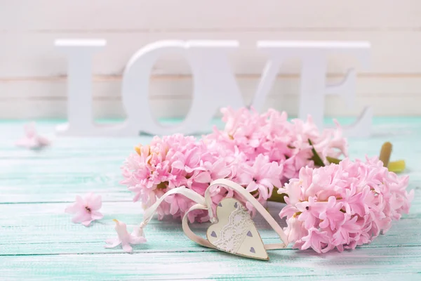 Roze bloemen, houten woord liefde — Stockfoto