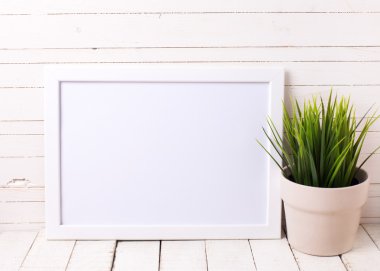 White empty frame and grass in pot 