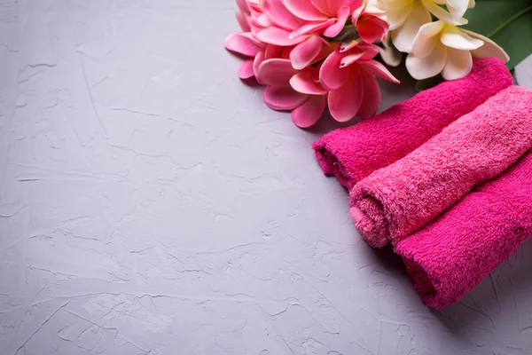 Rosa handdukar och tropiska blommor — Stockfoto