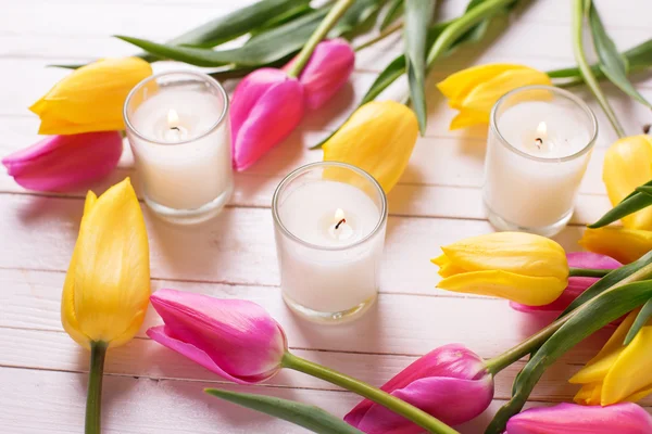 Tulips flowers and burning candles — Stock Photo, Image