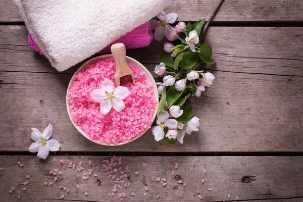 Różowa sól morska w misce i kwiatach — Zdjęcie stockowe
