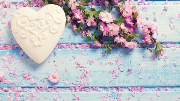 Sakura bloemen en witte decoratieve hart — Stockfoto
