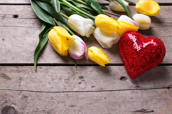 Frühlingstulpen und glänzendes dekoratives Herz — Stockfoto