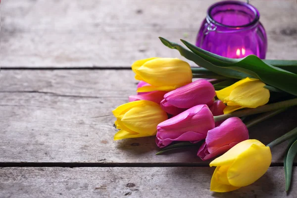 Spring tulips and violet candle — Stock Fotó