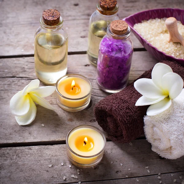 Bottles with aroma oil and plumeria flowers — Stock Photo, Image