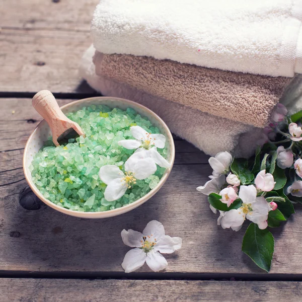 Green sea salt in bowl and flowers — Stock Photo, Image