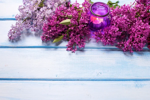 Fresh lilac flowers and candle — Stock Photo, Image