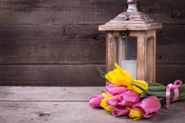 Tulipas de primavera e vela em lanterna — Fotografia de Stock