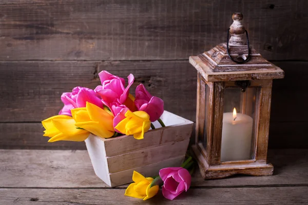 Spring tulips in box and candle — Stock Photo, Image