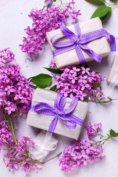 Wrapped gift boxes and lilac flowers — 图库照片